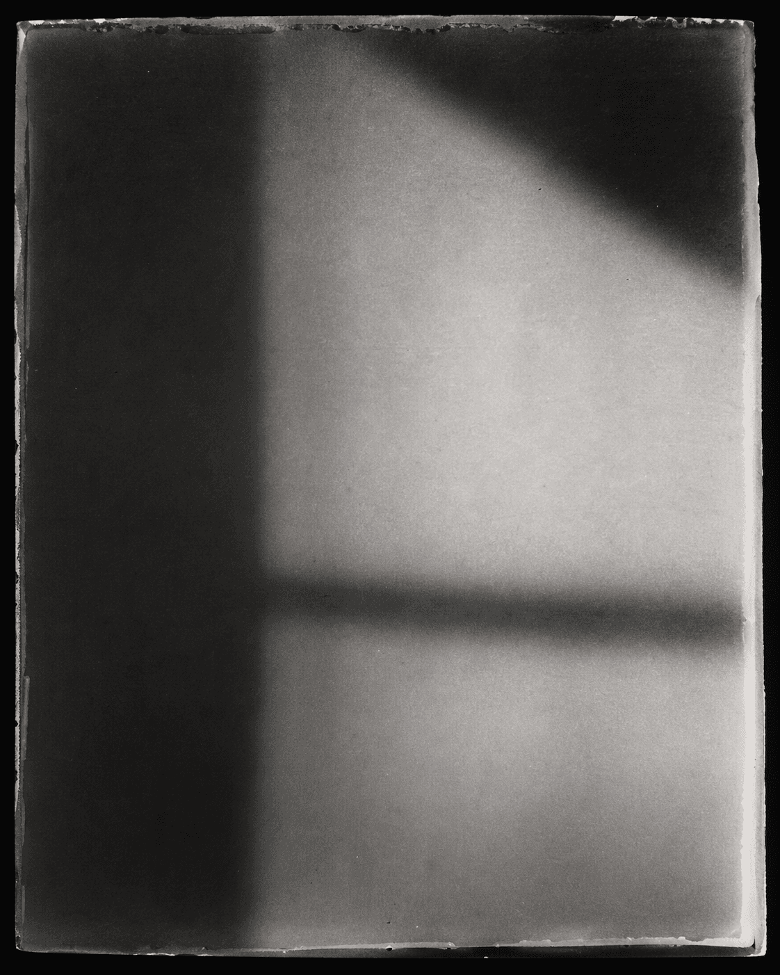 Abstract black-and-white analog photographic fragment with silver grain and emulsion edge